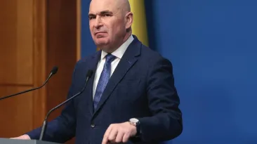 În epoca Bolojan, România se afundă tot mai mult: Corupția este în floare și țara noastră este sub media democrațiilor fragile
