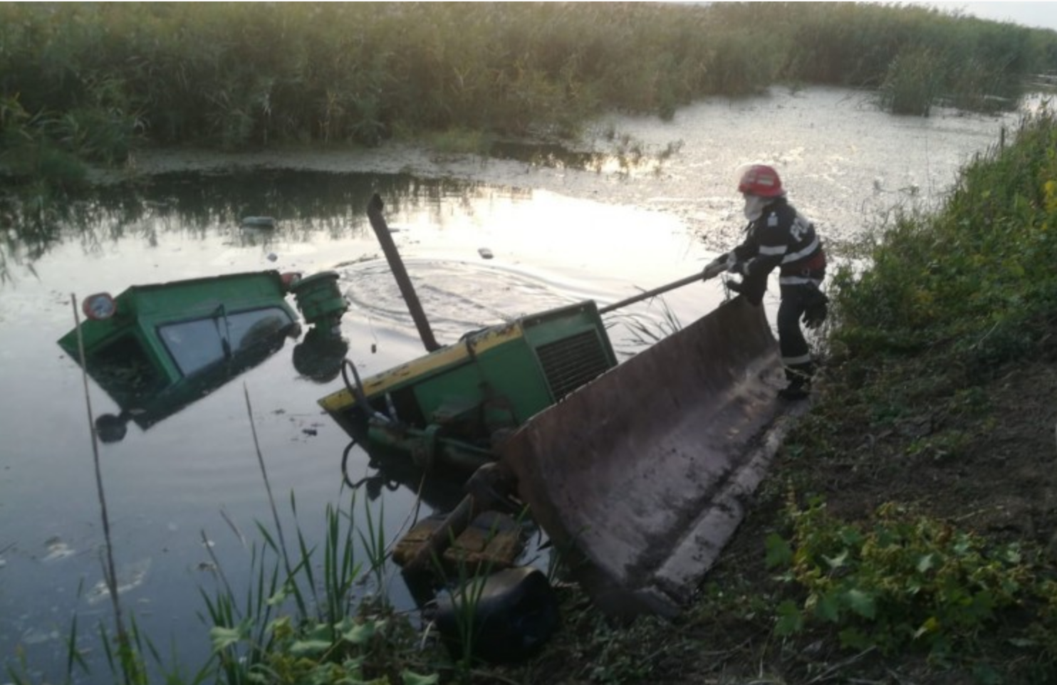 Buldozer, căzut într-un canal de irigaţii. Conducătorul utilajului a fost găsit prins în vegetația deasă