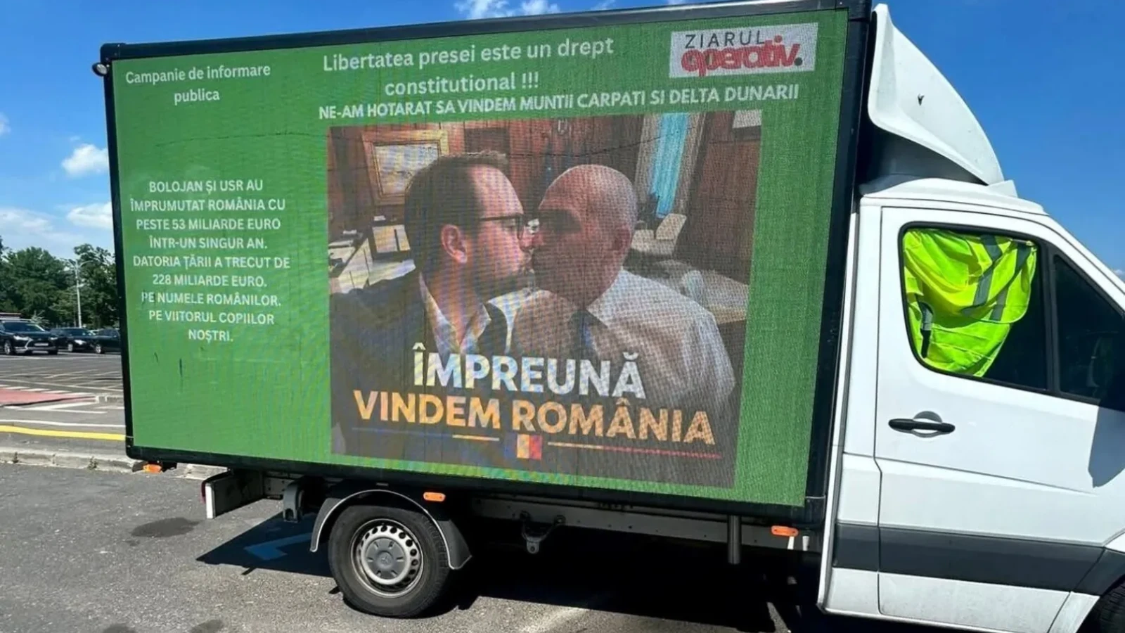Camion cu mesaj parcat în fața Guvernului: afișaj cu Bolojan și Fritz sărutându-se sub sloganul „Împreună vindem România