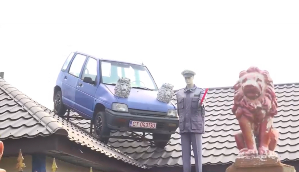 Protest inedit: Un bărbat și-a urcat mașina pe acoperișul casei după ce a rămas fără permis. A pus și un manechin îmbrăcat în uniformă de polițist